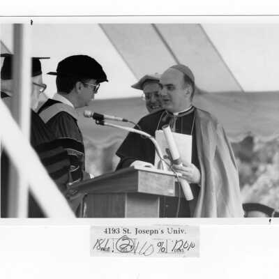 Honorary degree recipient, Bishop John P. Foley with Donald I. MacLean, S.J., James E. Dougherty during 1985 graduation/commencement.
