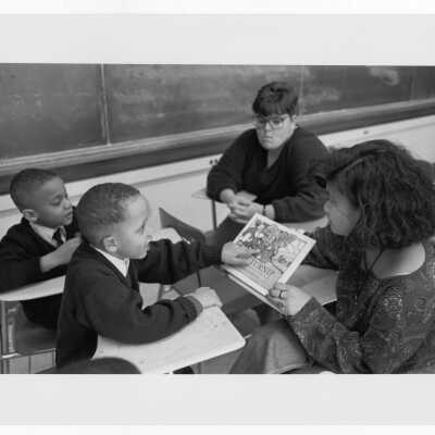 Student tutoring children in summer reading program (?), a community service/outreach project.