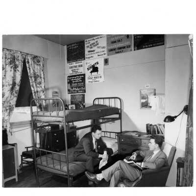 Two students in Veterans Barracks dorm room wearing coat and tie. Barracks located near Cardboard College also known as Barbelin Annex.