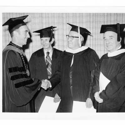 Terrence Toland, S.J., with members of class of 1923 (?, Golden Hawks) or Bene Merenti medalists (?) during 1973 graduation/commencement.
