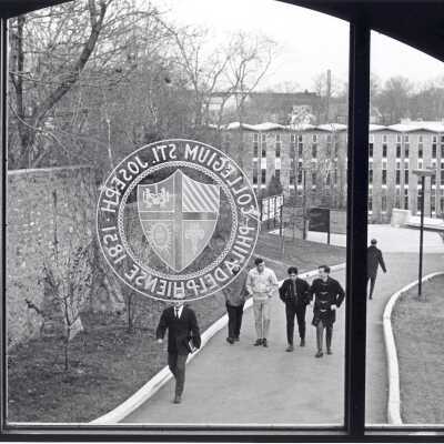 View of students walking alongside Gest estate wall toward Campion with Bellarmine in background. (Photo taken from inside Campion).