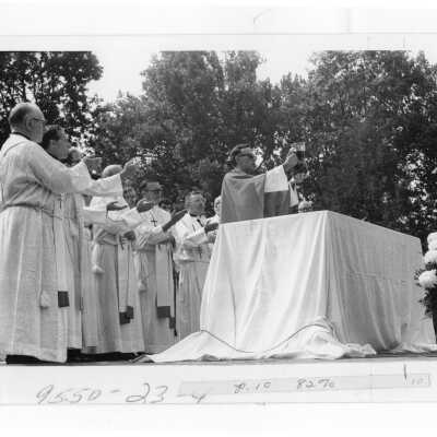 Donald I. MacLean, S.J., and concelebrators at consecration during Mass of the Holy Spirit held outside on campus grounds, September 1978.
