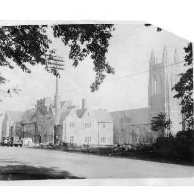 Exterior view of Barbelin building from City Avenue near end of construction with two automobiles in front.