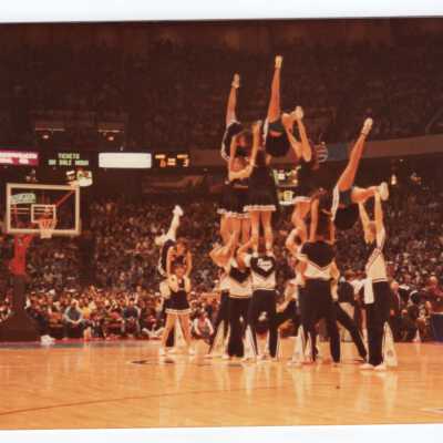 Men and women cheerleaders in a pyramid.