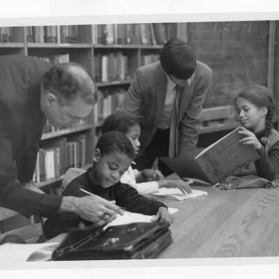Edward Brady, S.J., and student tutoring students at Rhoads Public School (?) as part of community service/outreach project. (Peace and Human Development program?)