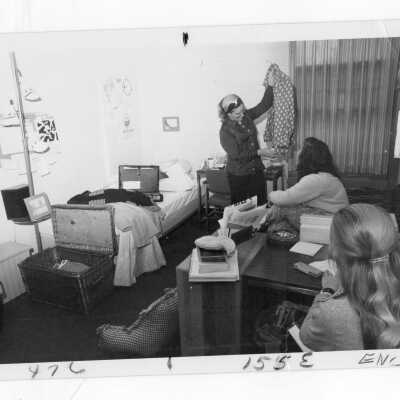 Three women students in dormitory room.