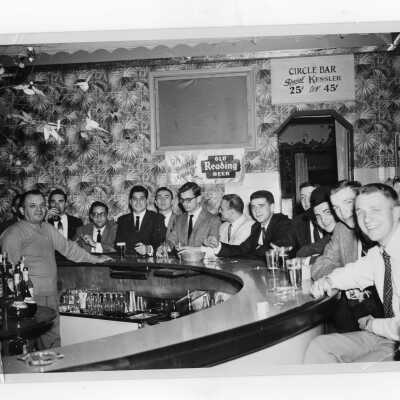 Student residents of Barry Hall gathered around table drinking soda.