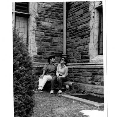 Two students sitting on corner bench in corner of Barbelin quadrangle.