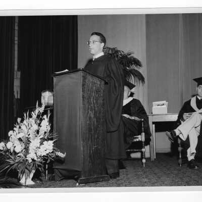 Tropaia exercises during 1955 graduation/commencement with Dominic Roberti giving class history at podium.
