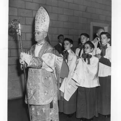 Pontifical mass celebrant, Bishop Hugh L. Lamb, leading procession in Field House as part of centennial celebration, October 28, 1951.