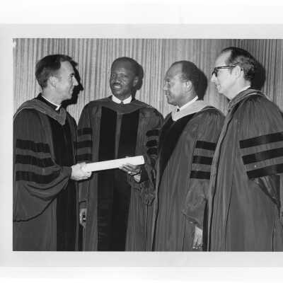 Francois Tombalbaye, President of Chad receives congratulations from Terrence Toland, S.J., other dignitaries after convocation, October 26, 1970.