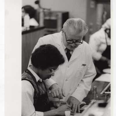 George Beichl, SJC chemistry professor, working with a high school student in laboratory as part of Chemistry Department's Science Motivation Program, c. 1972.