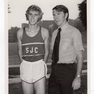 Men's track team member with Coach Kevin Quinn, 1974.
