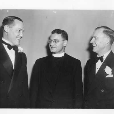 Edward G. Jacklin, S.J., with two guests (including Clare G. Fenerty?) during banquet held in Field House as part of centennial anniversary celebration.