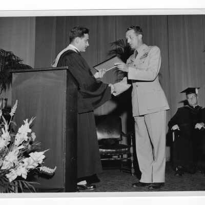 Tropaia exercises at 1955 graduation/commencement with Alumni President Ariano presenting award to Colonel Raymond Gehrig.