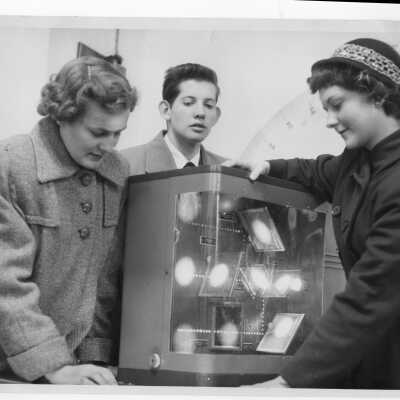 Three high school students examining science model in laboratory during an open house held on March 17, 1951 as part of centennial celebration. The event was billed as 'One Hundred Years and a Day of Science.'