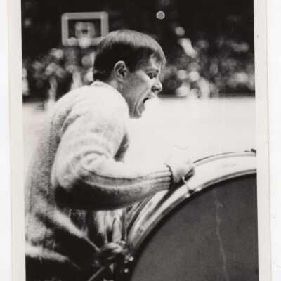 Men's Basketball, cheerleader playing drum at game.