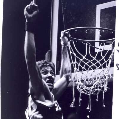 Men's Basketball player cutting victory net