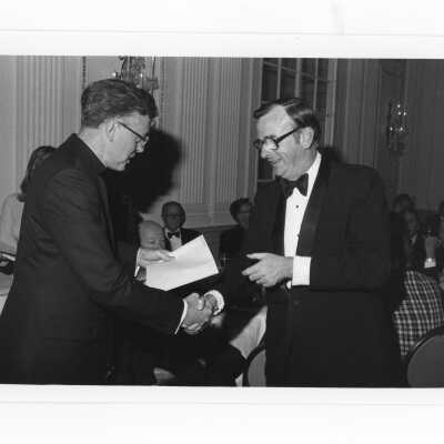Donald I. MacLean, S.J., handing awards to John Paul Curran, Louis Cissone, Richard J. Logan, Thomas J. McParland at alumni awards dinner, c. 1980.