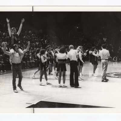 Men and women cheerleaders at basketball game.