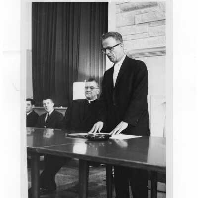 Paul D'Ortona, President of Philadelphia City Council addresses gathering in Campion Hall, c. 1965, with William F. Maloney, S.J., and students in backgrounds.