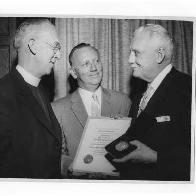 Dr. Bernard P. Widmann showing Shaffrey award medal and certificate to J. Joseph Bluett, S.J., and Dr. Tourish, April 27, 1958.
