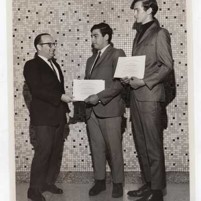 Dominic Roberti awarding certificates of merit to two high school students for participating in Chemistry Department's Science Motivation Program, spring 1968.