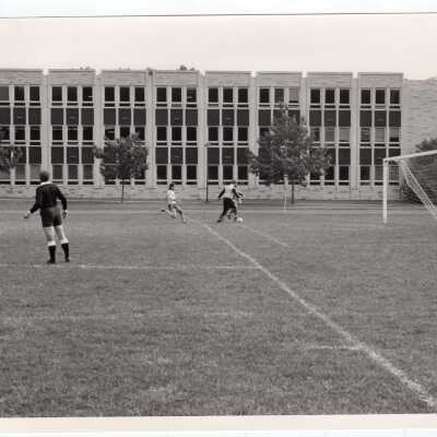 Men's soccer match with Post Hall (formerly Villiger) in background.