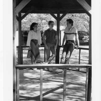 Students talking in gazebo of Gest Estate (now Wolfington Center) in spring. [not original structure; original made with tree limbs]