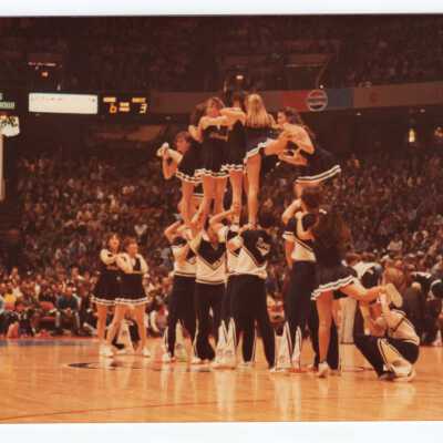 Men and women cheerleaders in a pyramid.