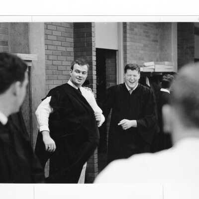 Graduates putting on robes in Bellarmine classroom during 1968 graduation/commencement.