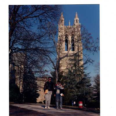 Exterior view of two male students walking in front of Barbelin Tower in late fall.