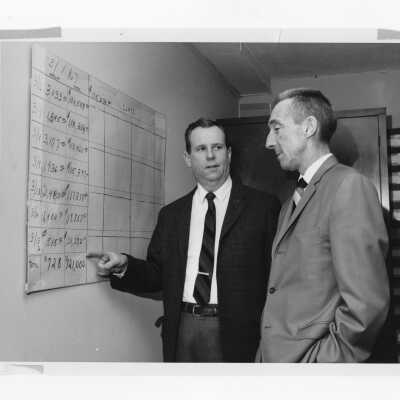 Frank A. Biglin and William J. Bates, Jr., annual giving directors of the alumni association looking at fundraising chart, 1967.