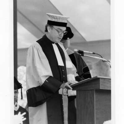 Francis F. Burch, S.J., reading honorary degree citation to Michael J. Smith, S.J. during 1985 graduation/commencement.