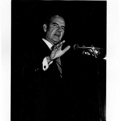 Senator George McGovern delivering speech from podium in Field House, October 2, 1969.