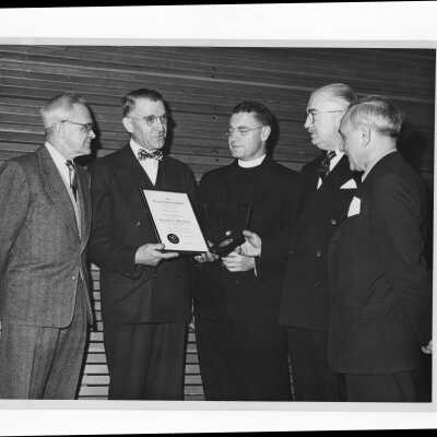 Dr. Louis H. Clerf showing his Shaffrey award medal and certificate to Edward G. Jacklin, S.J., Joseph W. Post, Eugene J. Garvin, and Pascal Lucchesi, March 30, 1952.