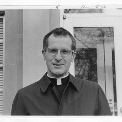 Frederick A. Homann, S.J.: Faculty, Mathematics. Fr. Homann is standing on grounds of Loyola Hall.
