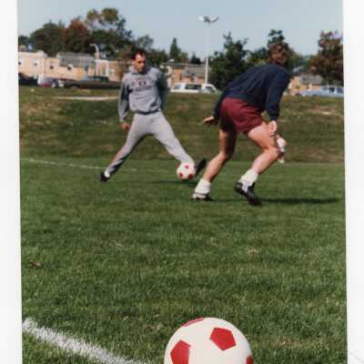 Two players on men's soccer team practicing.