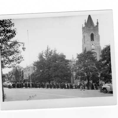 Students in cap and gown processing into Our Lady of Lourdes Church for Baccalaureate service as part of 1948 graduation/commencement service. There are three prints of students outside processing and one with an interior view of of the service.