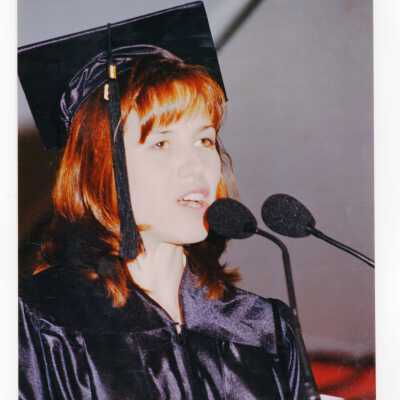 Graduate student, possibly either Pamela Clegg or Jacqui Lorenzo, addressing 1999 graduation/commencement.