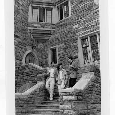 Two students and Jesuit walking down steps outside of Barbelin.