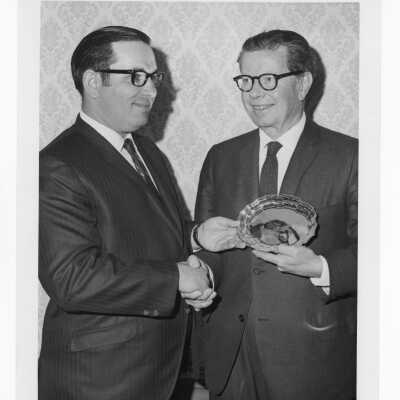 Richard J. Hughes receiving Law Alumni Award with another individual watching, December 2, 1969.