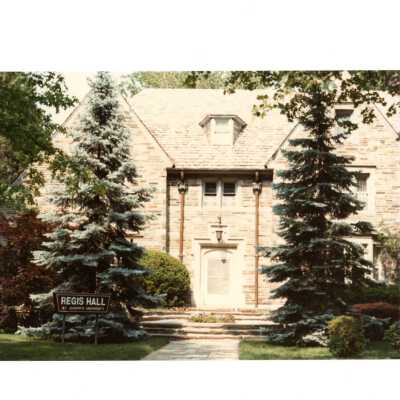 View of front of Regis Hall in spring.