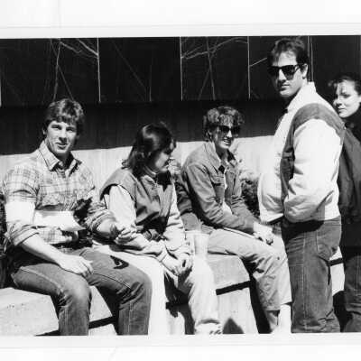 Several students sitting on wall and talking outside Campion.