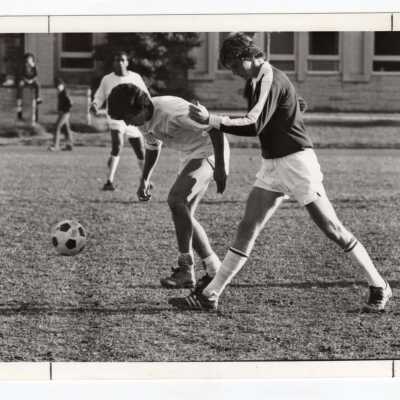 Men's soccer match on Finnesey Field with Post Hall (formerly Villiger) in background.