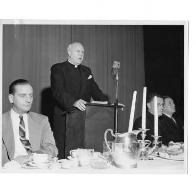 View of head table at alumni communion breakfast, October 30, 1955, including Charles Krull, Edward G. Jacklin, S.J., Frank Lammer, and Hunter Guthrie, S.J.