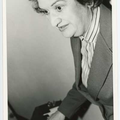 Madeline M. Conti: Administrative Assistant to the President. She is working the electrical board to ring the bells in Barbelin Hall tower. Accompanying contact sheet has photos of construction of Library addition.
