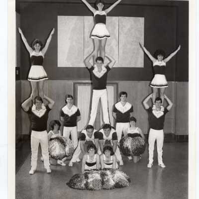Men and women cheerleaders in pyramid formation.