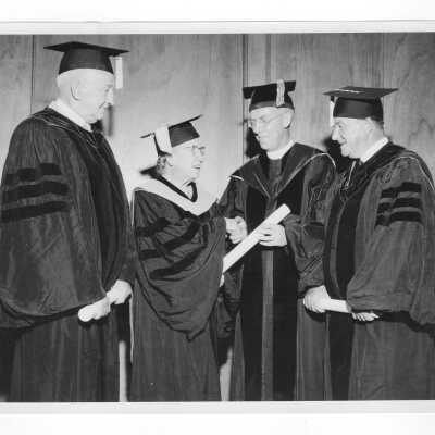 J. Joseph Bluett, S.J., with honorary degree recipients, Laura Leggett Barnes, Frank Casey, and Charles Carvin, during 1957 graduation/commencement.