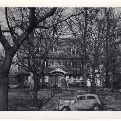 Front view of Barry Hall with car parked on street.